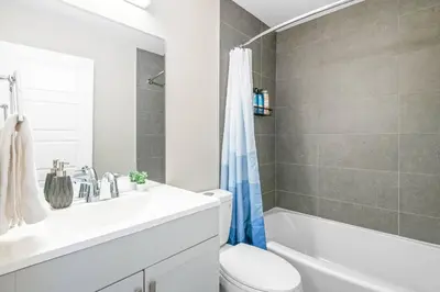 a bathroom with a toilet and a sink and a shower at Elegant Living in a 1-Bedroom Suite in Edmonton