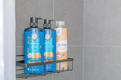 three bottles of shampoo and conditioner on a shelf at Elegant Living in a 1-Bedroom Suite in Edmonton