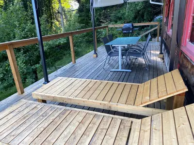 a wooden deck with a table and a bench at Cedar House Ocean View & Access in Roberts Creek