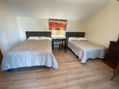 a bedroom with two beds and a table with a lamp at Cedar House Ocean View & Access in Roberts Creek