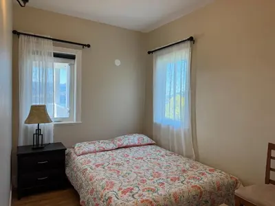 a bedroom with a bed and two windows at SHARED Lakeview Peaceful 2BR Stay in Beautiful Kelowna in Kelowna