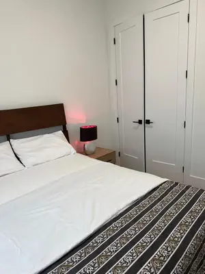 a bedroom with a white bed with a wooden headboard at Calm & Cozy Private Suite in Surrey