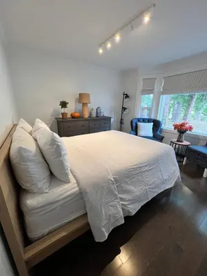 a bedroom with a large bed with white sheets at LF Guesthouse in Nanaimo
