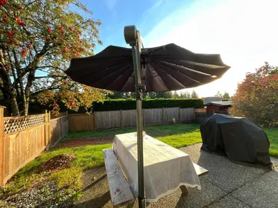 a black umbrella on a table in a backyard at LF Guesthouse in Nanaimo