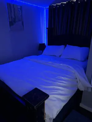 a bedroom with a bed with a blue light at ComfyComfort in Calgary