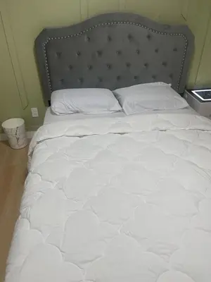 a white bed with a metal headboard and white pillows at Shiloh Residence in Edmonton