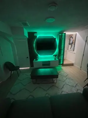 a living room with a green light on a tv at Shiloh Residence in Edmonton
