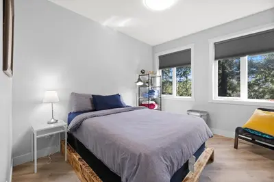a white bedroom with a bed and two windows at 4-bedroom with Game Room & Hot Tub in Fernie