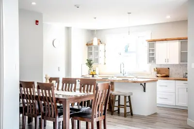 a kitchen with a table and chairs and a kitchen with white cabinets at 4-bedroom with Game Room & Hot Tub in Fernie