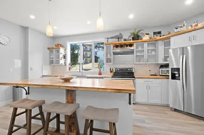 a kitchen with a large wooden table and stools at 4-bedroom with Game Room & Hot Tub in Fernie