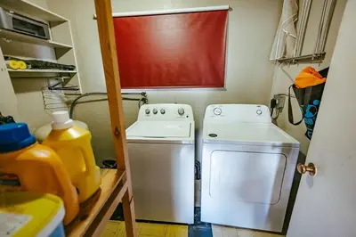 a small kitchen with a stove and a washer at Pet-Friendly Invermere Home with Firepit by StayIn in Lake Windermere