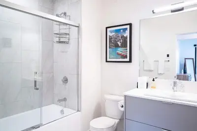 a bathroom with a shower and a toilet and a sink at Huckin' Harry's in Revelstoke