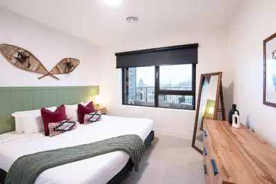 a bedroom with a large bed and a window at Huckin' Harry's in Revelstoke