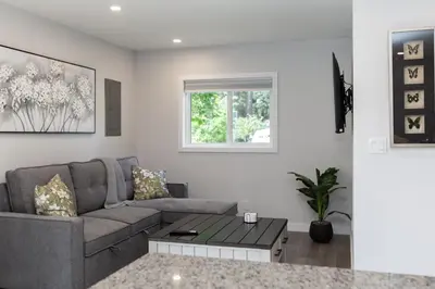 a living room with a couch and a table at Cozy 1-Bedroom Retreat in the Heart of Langford in Victoria