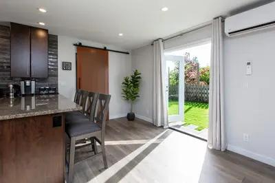 a kitchen with a counter and a table and chairs at Cozy 1-Bedroom Retreat in the Heart of Langford in Victoria