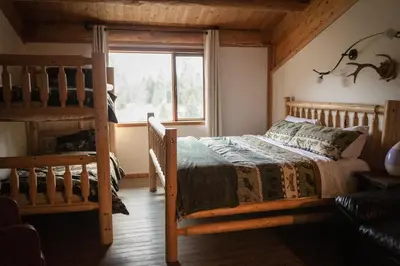 a bedroom with two bunk beds and a window at Off-Grid Mountain Lodge & 4 Cabins - Sauna, Hot Tub & Fishing in Rock Lake Provincial Park