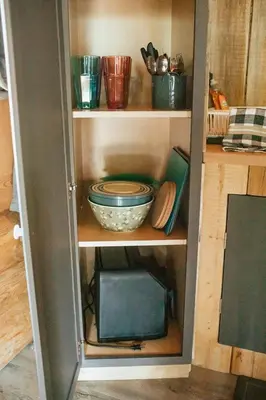 a cupboard with a bowl and other items in it at Off-Grid Mountain Lodge & 4 Cabins - Sauna, Hot Tub & Fishing in Rock Lake Provincial Park