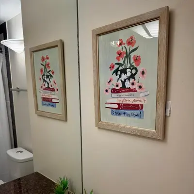 two framed pictures of flowers on a bathroom wall at Sea to Sky Studio with Mountain and City Views in Vancouver