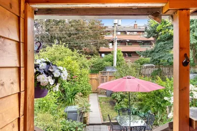 a patio with a table and an umbrella at Adorable Kits Home with Balcony and Garden Retreat in Vancouver
