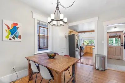 a kitchen and dining room with a wooden table and chairs at Adorable Kits Home with Balcony and Garden Retreat in Vancouver