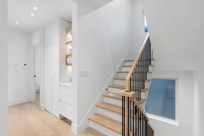 a staircase in a house with white walls and wooden floors at Duplex in West Point Grey with Parking and Balcony in Vancouver