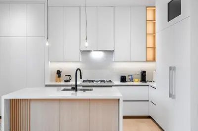a white kitchen with white cabinets and a sink at Duplex in West Point Grey with Parking and Balcony in Vancouver