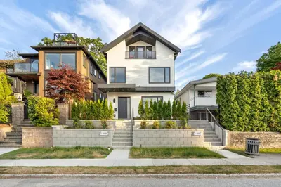 a white house with stairs and bushes at Duplex in West Point Grey with Parking and Balcony in Vancouver