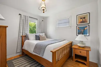 a bedroom with a bed and a window at Kinepik Cottage Sunroom with Beach Access in Sylvan Lake