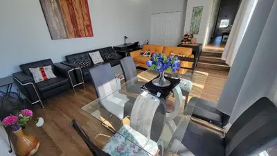 an aerial view of a living room with a glass table at 4-Bedroom Home by Downtown and Airport in Calgary