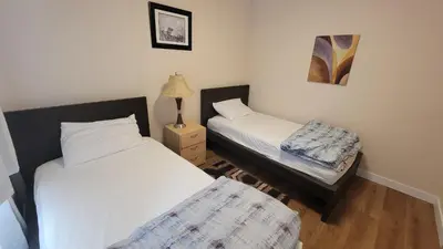 a room with two beds and a lamp in it at 4-Bedroom Home by Downtown and Airport in Calgary