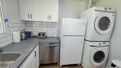 a kitchen with a white refrigerator and a washer and dryer at 4-Bedroom Home by Downtown and Airport in Calgary