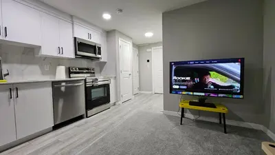 a kitchen with a flat screen tv on a wall at Spruce Meadows Place in Calgary