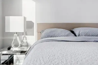 a bedroom with a bed with a lamp on a night stand at 17th Avenue Paranomas Escape in Calgary