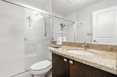 a bathroom with a toilet and a sink and a shower at 17th Avenue Paranomas Escape in Calgary