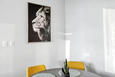 a dining room table with a lion picture on the wall at 17th Avenue Paranomas Escape in Calgary