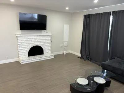 a living room with a fireplace with a flat screen tv at Cozy 3-Bedroom Retreat in Surrey Share Save in Surrey