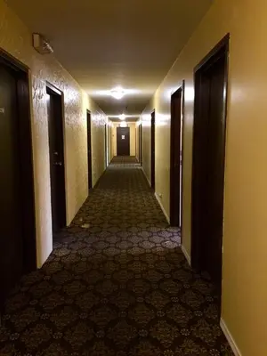 an empty hallway in a hotel with doorsopens at Villagers Inn in Fruitvale
