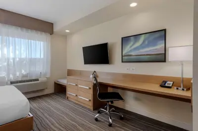 a hotel room with a desk and a television at Best Western Plus Sawridge Suites in Fort McMurray