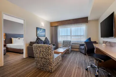 a hotel room with a bed and a desk at Best Western Plus Sawridge Suites in Fort McMurray