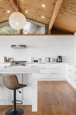 a kitchen with a white counter and a chair at Ocean's Embrace Suite in Nanaimo