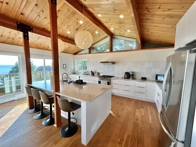 a kitchen with wooden ceilings and a large kitchen island at Ocean's Embrace Suite in Nanaimo
