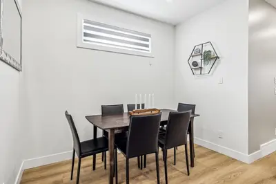 a dining room with a table and black chairs at Ultimate Group Stay, 3 King Beds, 2 Suites in Calgary