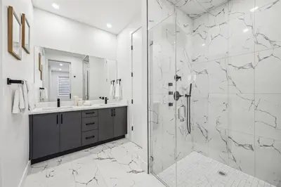 a white bathroom with a shower and a sink at Ultimate Group Stay, 3 King Beds, 2 Suites in Calgary