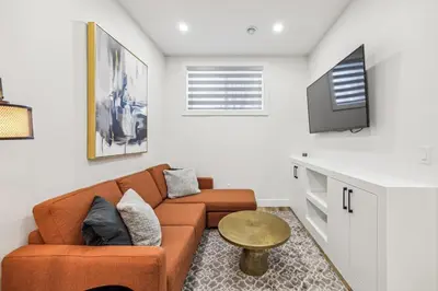 a living room with a couch and a tv at Ultimate Group Stay, 3 King Beds, 2 Suites in Calgary