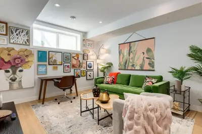 a living room with a green couch and a table at Santuario Kensington - Inner City Escape in Calgary