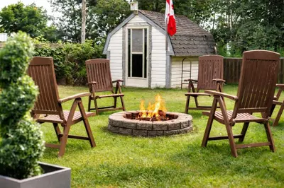 a group of three chairs around a fire pit at Sylvan Cabin - 3 BR Family Fun Luxurious Yard in Sylvan Lake