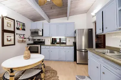 a kitchen with white cabinets and a table in it at Sylvan Cabin - 3 BR Family Fun Luxurious Yard in Sylvan Lake