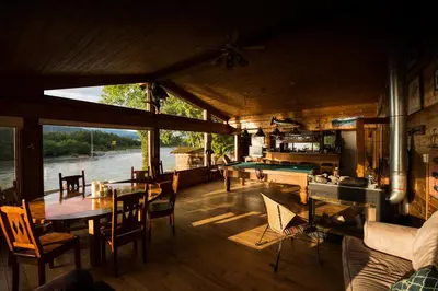 a living room with tables and a pool table at Skeena River House Bed & Breakfast in Terrace