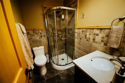 a bathroom with a shower and a toilet and a sink at Skeena River House Bed & Breakfast in Terrace