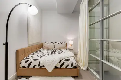 a bedroom with a bed with a black and white comforter at 2 Storey Penthouse Panoramic Views Parking Stampede in Calgary